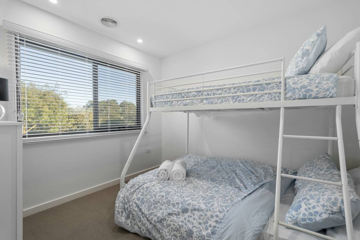 Infographic showing space saved by bunk beds vs two single beds in a 10x10 room: bunk beds free up 42 sq ft for play or storage